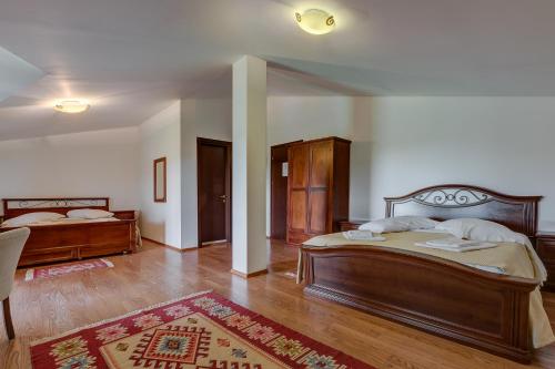 a large bedroom with two beds and a rug at Club Insieme Grand Resort in Potlogi