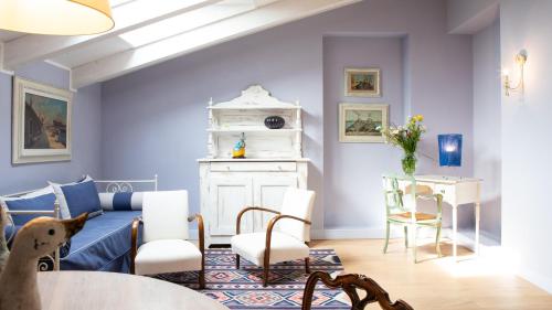a living room with blue walls and a table and chairs at Villa Belverde Boutique Hotel in Carrara