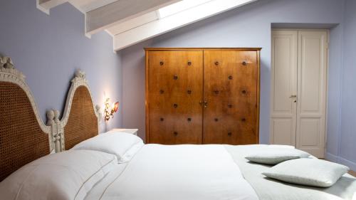 a bedroom with a white bed and a wooden cabinet at Villa Belverde Boutique Hotel in Carrara