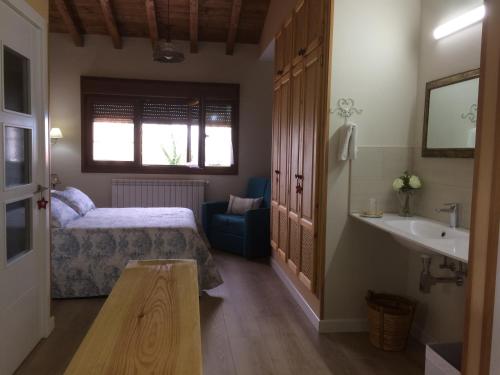 a bedroom with a bed and a sink and a mirror at La Llastra de Garaña in Llanes