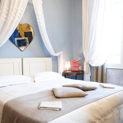a bedroom with two beds with pillows on them at Villa Belverde Boutique Hotel in Carrara