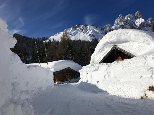 a building covered in snow in front of a mountain at Zur lieben Sonne in Filzmoos
