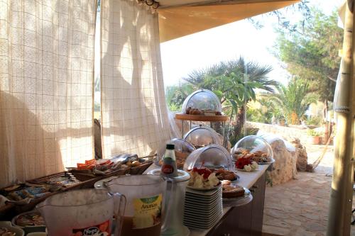 a buffet with plates and food on a table at Luagos club Resort in Lampedusa