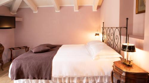 a bedroom with a white bed and a table at Villa Belverde Boutique Hotel in Carrara