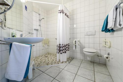 a bathroom with a shower and a sink and a toilet at Hotel Böving in Breckerfeld