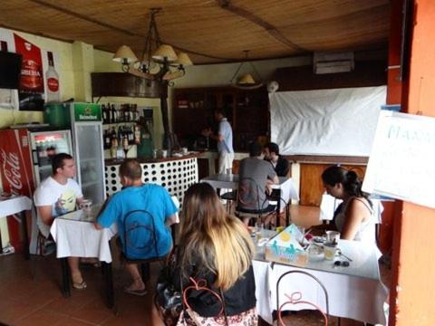 un groupe de personnes assises à table dans un restaurant dans l'établissement Hostel Ibirapita, à La Paloma