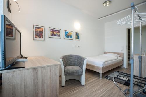 a room with a bed and a tv and a couch at Hotel Böving in Breckerfeld