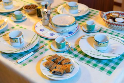 a table with cups and plates of food on it at B&B La Stradella in Ostuni