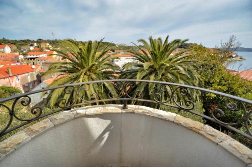 a balcony with a view of a city and palm trees at Villa Carmen in Sali