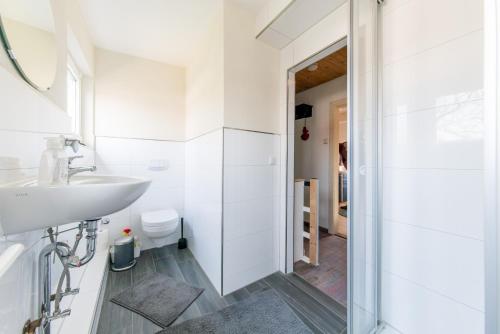 a white bathroom with a sink and a shower at Private Apartment in Hannover