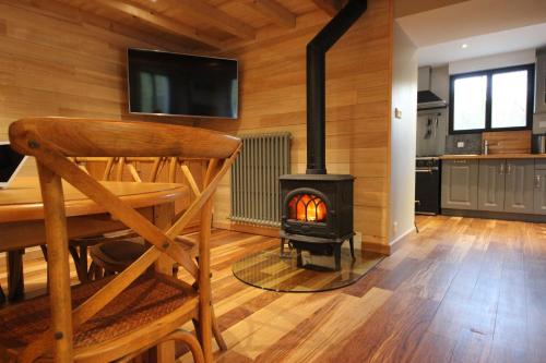 a dining room with a woodburning stove in a room at Monyoya ,site exceptionnel au coeur des Pyrénées in Sarrance