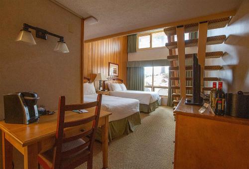 a hotel room with two beds and a desk with a desk at Fairmont Hot Springs Resort in Fairmont Hot Springs