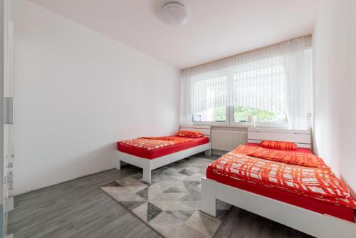 een slaapkamer met 2 bedden en een raam bij Privatapartment Messe Süd in Hannover