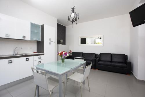 a kitchen and living room with a glass table and chairs at Selenite in Capo dʼOrlando