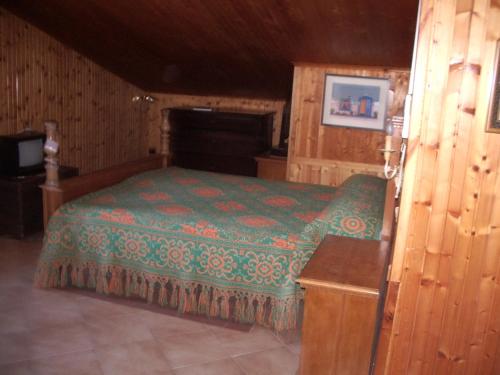 マラネッロにあるB&B La Pilastrinaの木製の部屋にベッド1台が備わるベッドルーム1室があります。