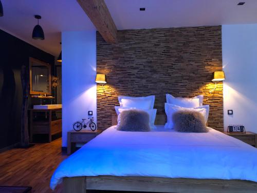 a bedroom with a large bed with a brick wall at Les suites sainte claire in Annecy