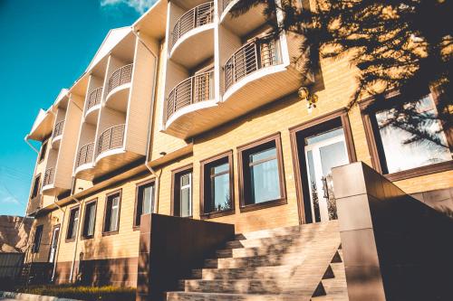 a large building with stairs in front of it at Aska Hotel in Naryn