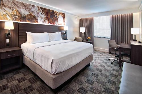Pokój hotelowy z dużym łóżkiem i biurkiem w obiekcie Crowne Plaza Executive Center Baton Rouge, an IHG Hotel w mieście Baton Rouge