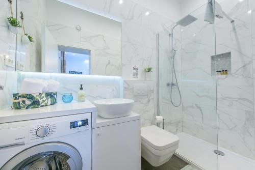a white bathroom with a washing machine and a shower at Arcus Apartment & Arcus Room in Split