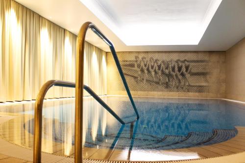 a swimming pool with a staircase in a building at SEETELHOTEL Strandhotel Atlantic das Boutiquehotel am Meer in Bansin