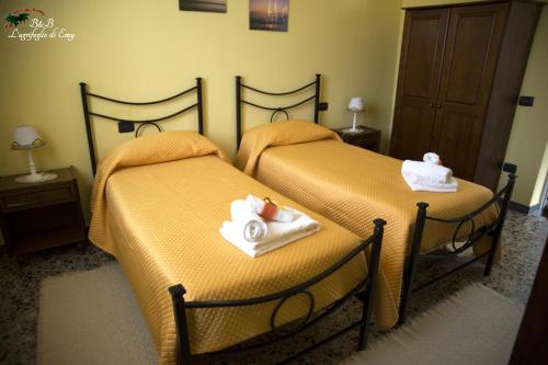 2 Betten in einem Hotelzimmer mit Handtüchern darauf in der Unterkunft L'Agrifoglio di Emy in Guspini