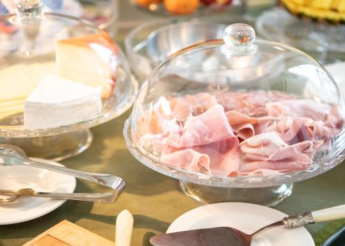 a table topped with plates and bowls of food at Villa Belverde Boutique Hotel in Carrara