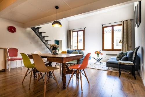 une salle à manger et un salon avec une table et des chaises dans l'établissement Sunny, Breezy Gem in the Centre of the Old City, à Arles