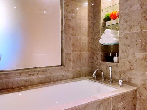 a bath tub in a bathroom with a mirror at SKY POOL Stylish Suite 2-7Pax at KL City in Kuala Lumpur