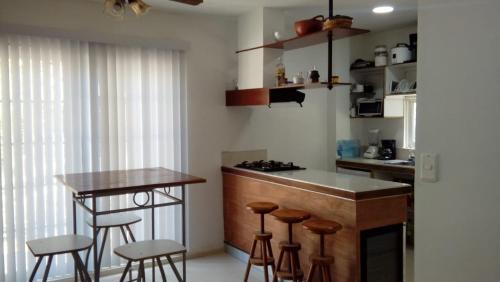 eine Küche mit einer Bar mit Hockern und einem Tisch in der Unterkunft Hostal green bay in San Andrés