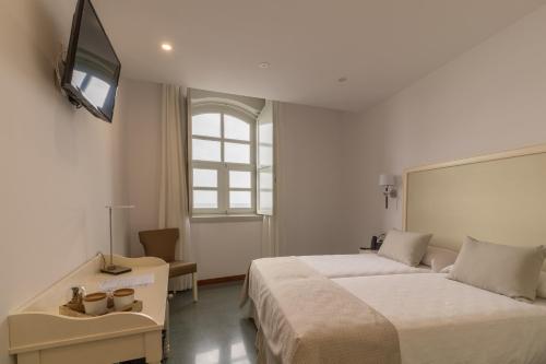 a hotel room with two beds and a television at Hotel Emblemático Holiday Time in Santa Cruz de la Palma