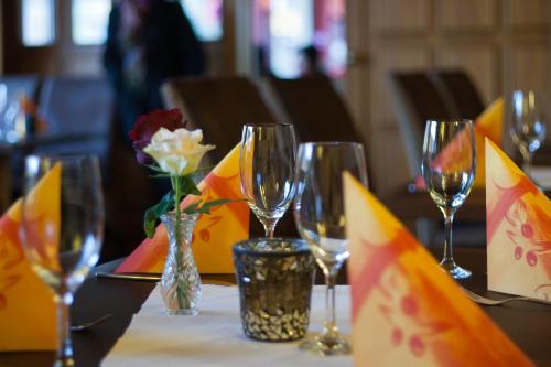 - une table avec des verres à vin et des fleurs dans l'établissement Hotel Zum Fährturm, à Mehring