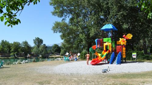 a child standing next to a playground at Glamping Villatent at Le Lac Bleu in Châtillon-en-Diois