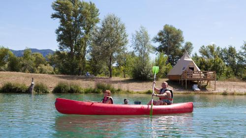 a man and a woman in a red canoe on the water at Glamping Villatent at Le Lac Bleu in Châtillon-en-Diois