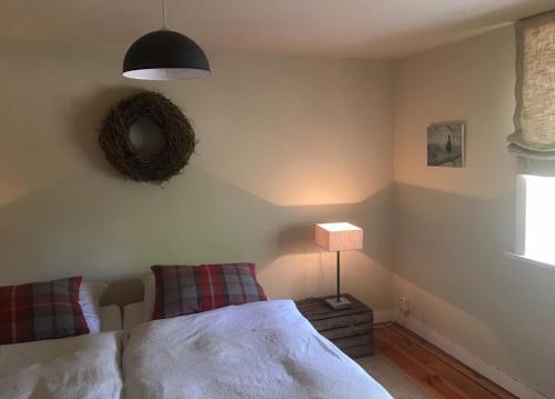 a bedroom with a bed and a lamp and a window at Ferienwohnung Alte Scheune in Egestorf