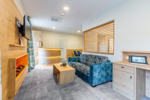 a living room with a blue couch and a tv at Schwan und Post Business Quarters in Bad Neustadt an der Saale