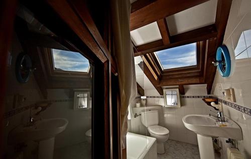 a bathroom with two toilets and a sink and a tub at El Camino Real II * in Poo de Cabrales