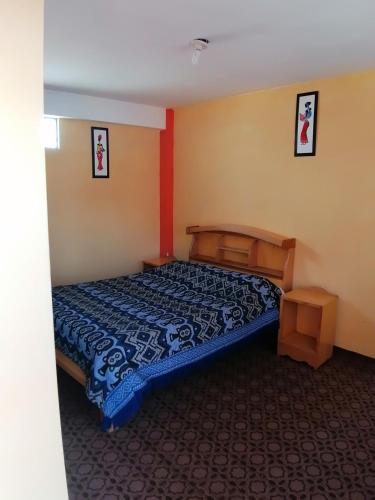 a bedroom with a bed with a blue comforter at Hostal Puerto Alegre in Copacabana