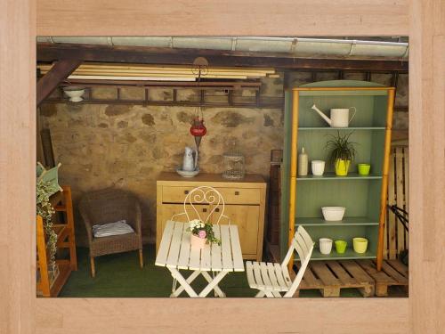 une chambre avec une table et des chaises dans une maison dans l'établissement LES HORTENSIAS, à Sainte-Marie-aux-Mines