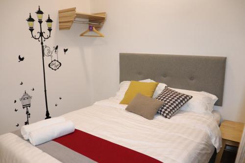 una camera da letto con letto, lenzuola e cuscini bianchi di BELLE VILLE a Muar