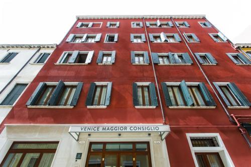 a red building with a sign on it at Venice Maggior Consiglio in Venice