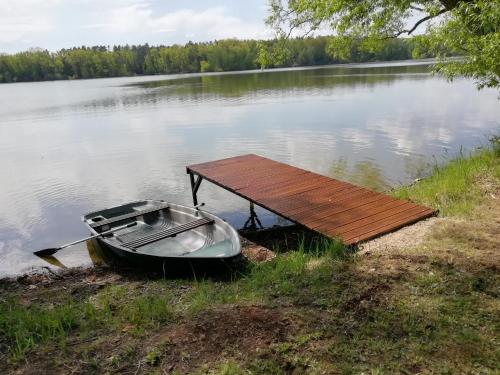 a boat parked next to a dock on a lake at Penzion Starobor in Sedlice