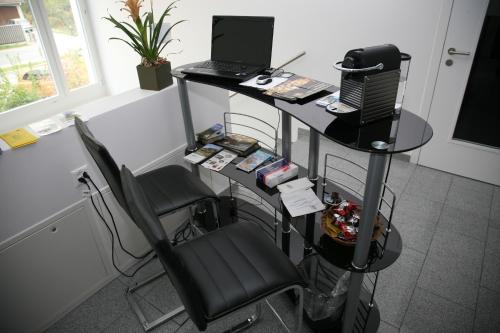 a desk with a laptop and a chair in a room at Gasthaus Post in Willisau
