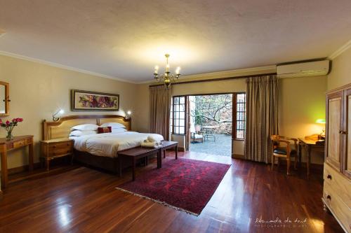 a bedroom with a bed and a table and a desk at Kleinkaap Boutique Hotel in Centurion