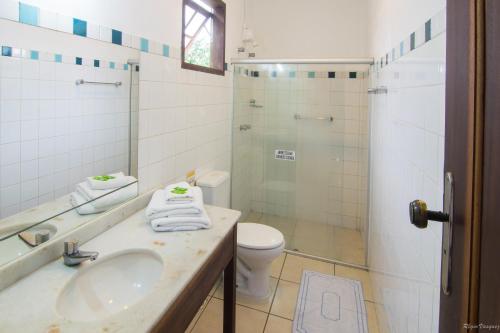 een badkamer met een wastafel, een toilet en een douche bij Pousada La Cigale in Paraty