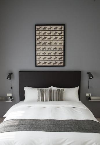 a bedroom with a white bed with a picture on the wall at Home In Tainan in Tainan