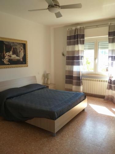 a bedroom with a bed and a ceiling fan at La Casa di Zoe - Terre del Magra in Bocca di Magra