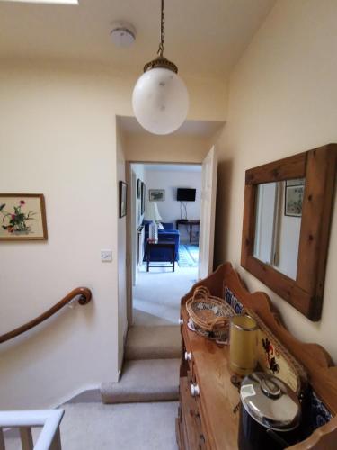 a living room with a wooden table and a hallway at Leithen Lodge in Innerleithen