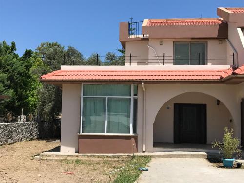 a house with a large window and a door at Suluca Homes in Kérynia