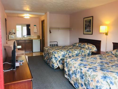a hotel room with two beds and a television at Mountain Country Motor Inn in Branson West