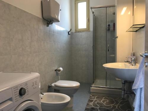 a bathroom with a toilet and a sink and a washing machine at 35G Borgonovo in Pizzo